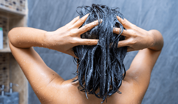 woman shampooing her hair in the shower