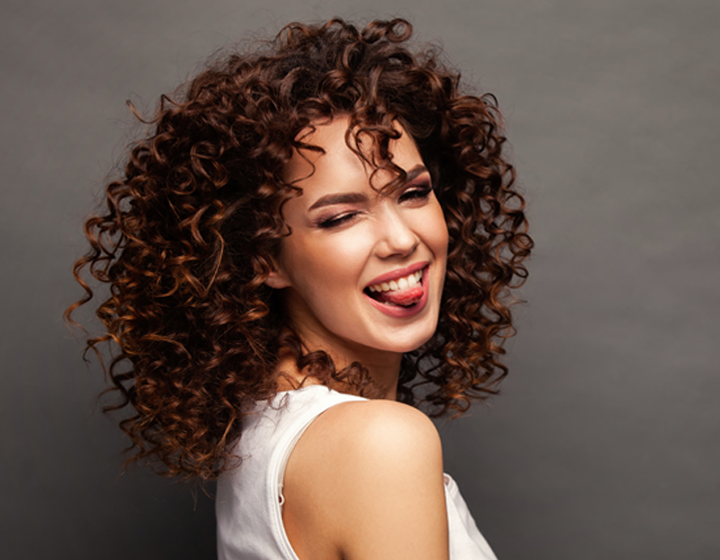 Woman sticking her tongue out with long curly hair