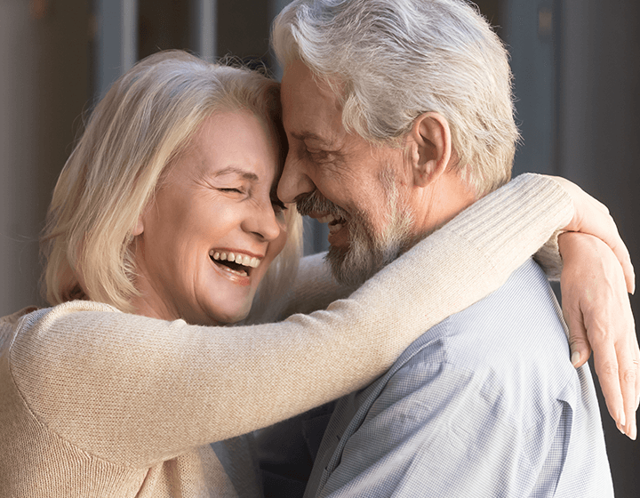 Elderly couple hugging and smiling