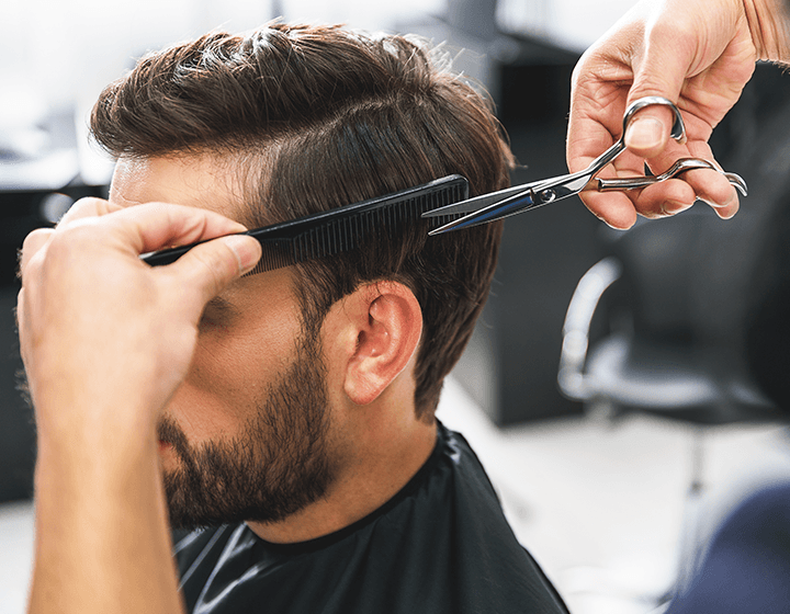 Man getting a haircut with scissors and a comb