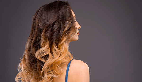 model with blended balayage brunette roots to warm blonde tips