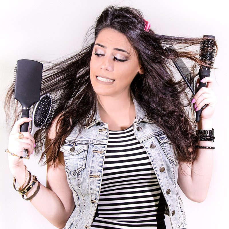 girl with 4 brushes tangled in her hair