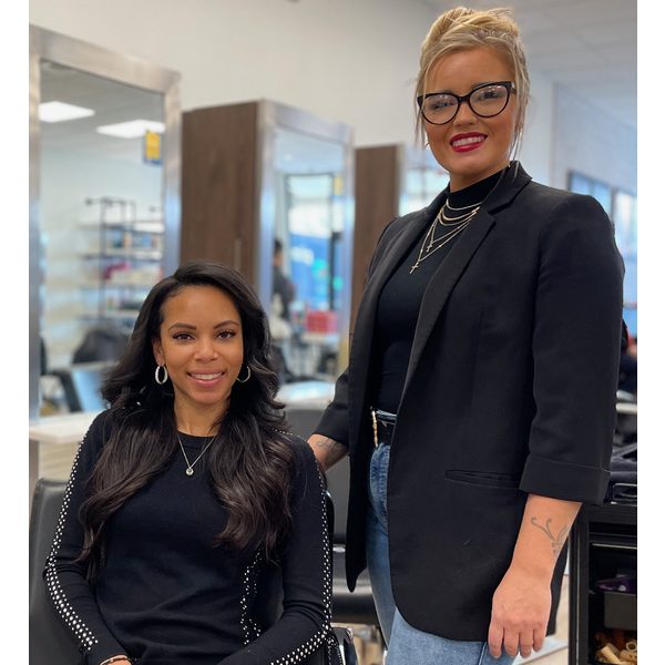 A Haircuttery stylist smiling with her satisfied customer