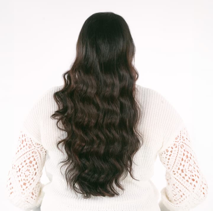 Woman with long, dark, and shiny hair shows Olaplex treatment results