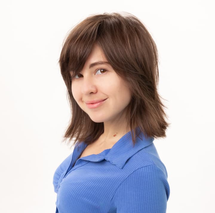 Woman with neck-length shag haircut smiling at camera.