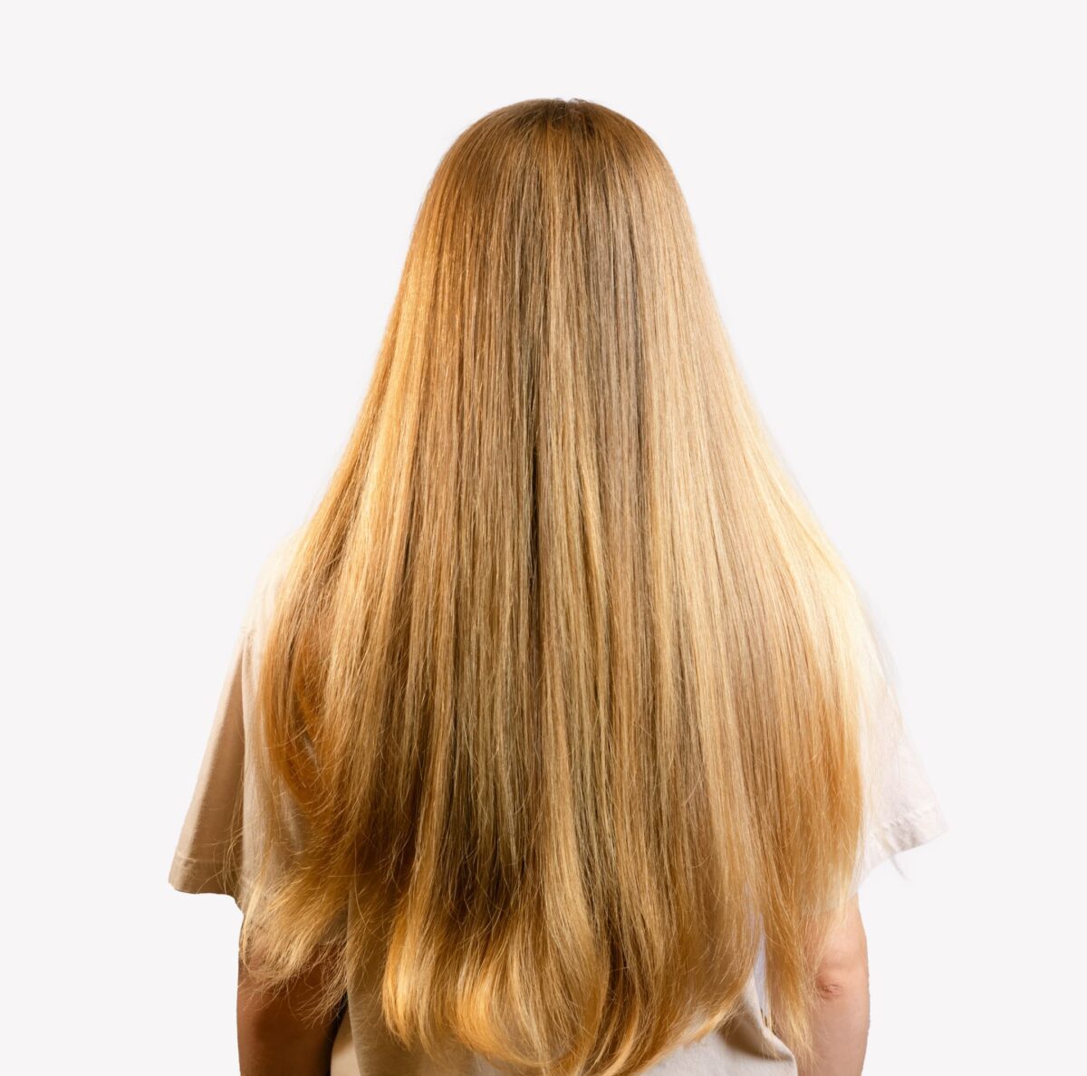 Woman with elbow-length hair showing Revive Restore results.