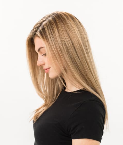 Woman shows her flat iron straightened hair.